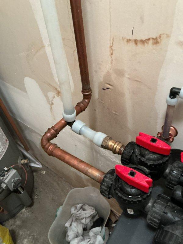 Responded to significant water leak in plumbing system connected to water softener. Upon inspection, identified failed Press 90 fitting as source of leak. Replaced compromised piping section from main water shut-off valve to water softener inlet using copper pipe and appropriate fittings. Installed new ball valves with red handles for improved shut-off control. Tested system for proper water flow and verified no additional leaks present. System restored to full operation with secure connections throughout repaired section.