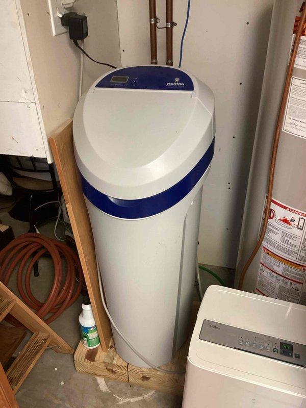 Completed comprehensive plumbing inspection at new commercial location, evaluating exposed wall cavity plumbing system including black PVC drain lines, copper supply piping, and associated fittings and connections. Inspected water treatment system including water softener unit with proper electrical connection and copper supply line routing in utility area. All plumbing systems photographed and documented for compliance verification.