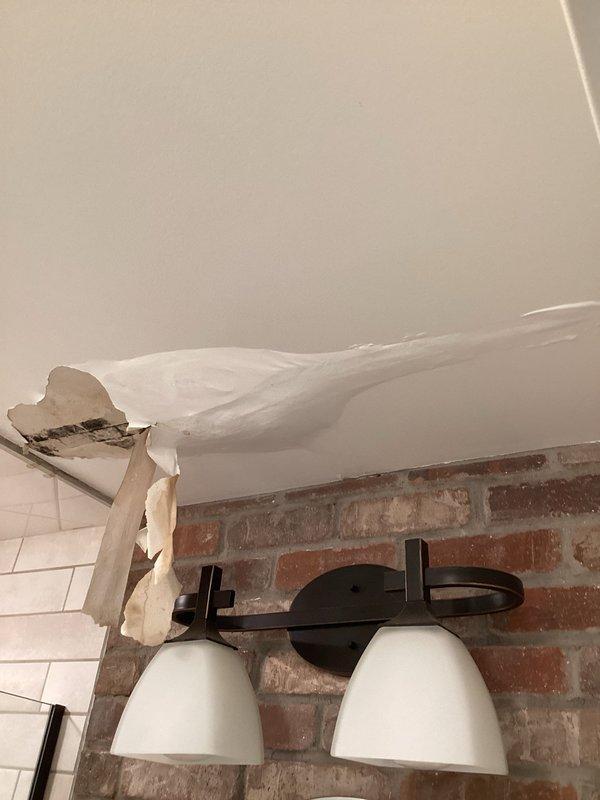 Responded to water leak complaint affecting basement bathroom ceiling. Upon inspection, identified active leak originating from Whirlpool dishwasher located on floor above. Water damage evident on bathroom ceiling with peeling paint and sagging material. Determined dishwasher leaks during operation cycle. Documented conditions with photos showing affected dishwasher unit and resulting ceiling damage. Advised customer that dishwasher replacement is necessary to resolve leak issue.