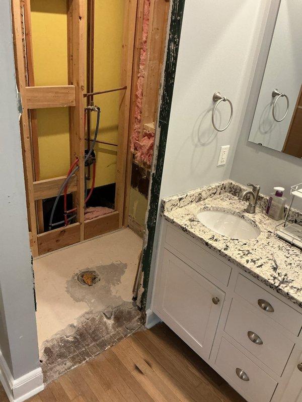 Responded to water leak in second-floor bathroom shower. Accessed property using provided entry code with authorization to complete work in absence of occupant. Removed existing dual valve shower system that was causing leak. Installed two owner-supplied Delta shower valves as replacements. Wall required demolition to access plumbing connections, exposing copper supply lines and drain pipes within stud cavity. Completed valve installation and verified proper operation with no active leaks upon completion.
