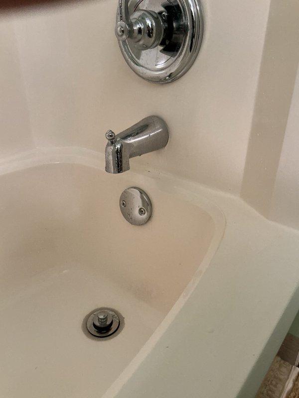 Responded to basement bathroom requiring replacement of worn tub spout and pop-up drain assembly. Removed existing fixtures and installed new chrome Moen slip-fit tub spout and complete pop-up drain assembly with overflow plate and stopper mechanism. Verified all threaded connections were properly sealed, tested water flow through new spout, confirmed pop-up stopper operation, and inspected all connections for leaks with system under pressure. All fixtures functioning correctly upon completion.