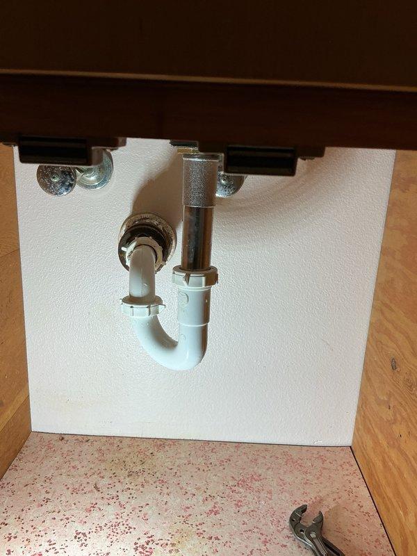 Responded to multiple plumbing issues throughout the residence involving kitchen and bathroom fixtures. Addressed leak underneath kitchen sink caused by deteriorated continuous waste piping; removed and replaced corroded metal drain assembly with reconfigured piping to ensure proper drainage and eliminate leak. Resolved low cold water pressure issue at bathroom faucet by removing and cleaning stem assembly, restoring adequate flow. Installed replacement pop-up drain assembly in bathroom vanity where previous mechanism was missing. Assessed toilet with inefficient flushing performance; replacement deferred pending homeowner decision. All completed repairs tested and verified operational.
