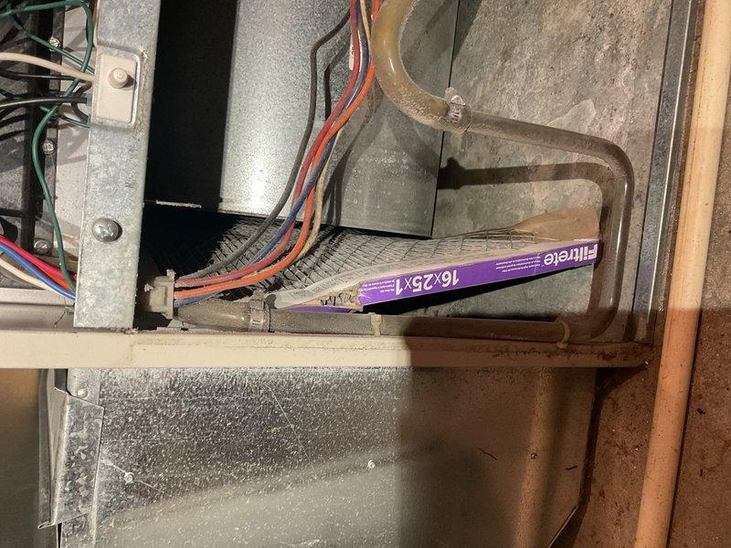 Performed annual maintenance on 23-year-old R22 air conditioning system that had not been serviced in approximately eight years. Homeowner reported diminished airflow and reduced cooling capacity in upper level over time. Upon inspection, discovered dual filtration issue: new filter present in filter rack, but second filter lodged against blower assembly that appeared over one year old and heavily restricted. Removed old filter from blower compartment, resulting in immediate improvement to system airflow. 

Tested capacitor rated at 35/5 µF, reading 25.6/4.9 µF—within acceptable range but showing age-related degradation. Conducted refrigerant analysis on R22 system and determined unit appears slightly undercharged, though no leak testing performed at this time. Documented findings and advised homeowner that system has reached legacy status due to age and R22 phase-out. Recommended consultation with comfort advisor to discuss system replacement options given equipment age and performanc