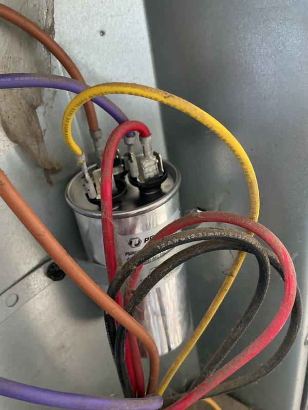 Responded to no cooling complaint on Goodman residential air conditioning system. Upon arrival, confirmed outdoor unit condenser fan was not operating while compressor attempted to run. Performed diagnostic testing and identified failed dual run capacitor as root cause of fan motor failure. Capacitor tested out of specification and showed signs of degradation. Removed defective capacitor and installed new replacement capacitor with proper microfarad ratings for both fan and compressor circuits. Reconnected all electrical terminals, verified proper wire routing and connections. Tested system operation and confirmed condenser fan motor now running at proper speed. Verified compressor starting and running normally. System cooling properly and operating within manufacturer specifications at time of departure.