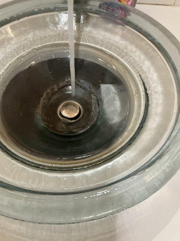 Responded to a bathroom sink drain clog caused by hair accumulation in the pop-up assembly. Removed and cleaned the pop-up drain assembly, clearing all hair buildup and debris from the drain mechanism. Tested water flow after reassembly to confirm proper drainage was restored.