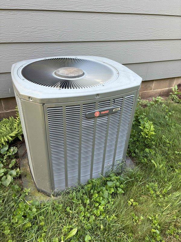 Responded to no-cool complaint on 2008 Trane system with reported evaporator coil freezing. Upon arrival, started system and connected manifold gauges, revealing low refrigerant charge on R-410A system. Verified adequate airflow through system, confirmed air filter and blower assembly were clean and unobstructed. Coil was not frozen at time of inspection as system had been off overnight per occupant instruction. Diagnosed refrigerant leak in system causing low suction and discharge pressures. Provided estimates for leak detection and repair services. Given the age of the equipment (15+ years old), discussed system longevity and efficiency concerns with occupant and recommended scheduling appointment with comfort advisor to review replacement options. Coordinated advisor visit for same day. System left in non-operational status due to insufficient refrigerant charge and active leak preventing proper cooling function.
