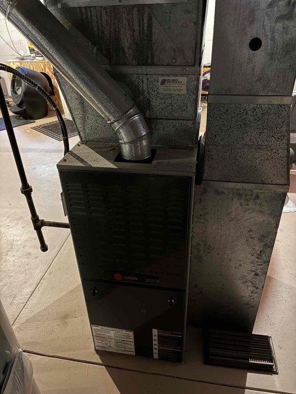 Responded to no-cool complaint on 2008 Trane system with reported evaporator coil freezing. Upon arrival, started system and connected manifold gauges, revealing low refrigerant charge on R-410A system. Verified adequate airflow through system, confirmed air filter and blower assembly were clean and unobstructed. Coil was not frozen at time of inspection as system had been off overnight per occupant instruction. Diagnosed refrigerant leak in system causing low suction and discharge pressures. Provided estimates for leak detection and repair services. Given the age of the equipment (15+ years old), discussed system longevity and efficiency concerns with occupant and recommended scheduling appointment with comfort advisor to review replacement options. Coordinated advisor visit for same day. System left in non-operational status due to insufficient refrigerant charge and active leak preventing proper cooling function.