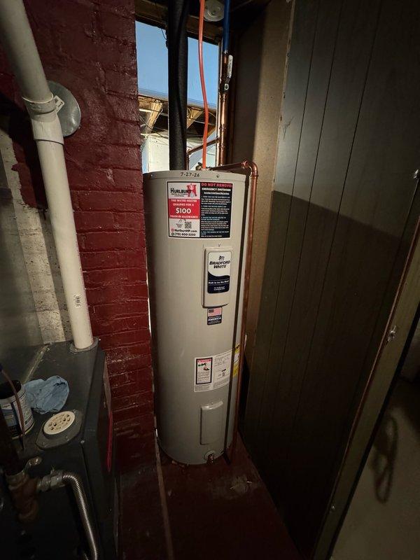 Completed installation of a standard 50-gallon electric water heater in basement utility room, replacing existing unit of similar specifications. Drained and removed old water heater, then positioned new unit against brick wall with proper clearances. Installed expansion tank to protect home's water lines, fixtures, and extend tank life. Ran new dedicated electrical circuit for water heater, including opening and closing ceiling access as needed. Connected copper supply lines with brass fittings and completed all plumbing connections per code requirements. Verified proper operation of all components including pressure relief valve, expansion tank function, and electrical connections. New unit includes 10-year parts and tank warranty with 1-year labor warranty.