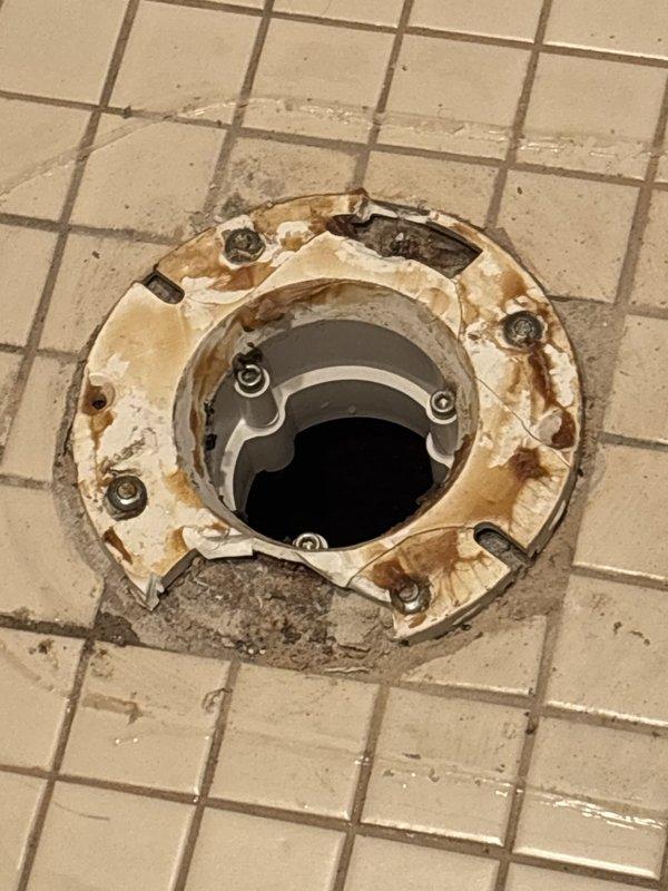 Responded to service call for broken toilet flange repair. Upon arrival, found severely corroded and deteriorated cast iron closet flange with extensive rust damage and structural failure. Removed damaged 4" closet flange assembly and prepared floor opening for replacement. Installed new metal repair collar and closet flange, securing all fasteners properly to ensure stable toilet mounting. Verified proper alignment and structural integrity of new flange installation. Documented existing conditions and completed repairs with photographic evidence.