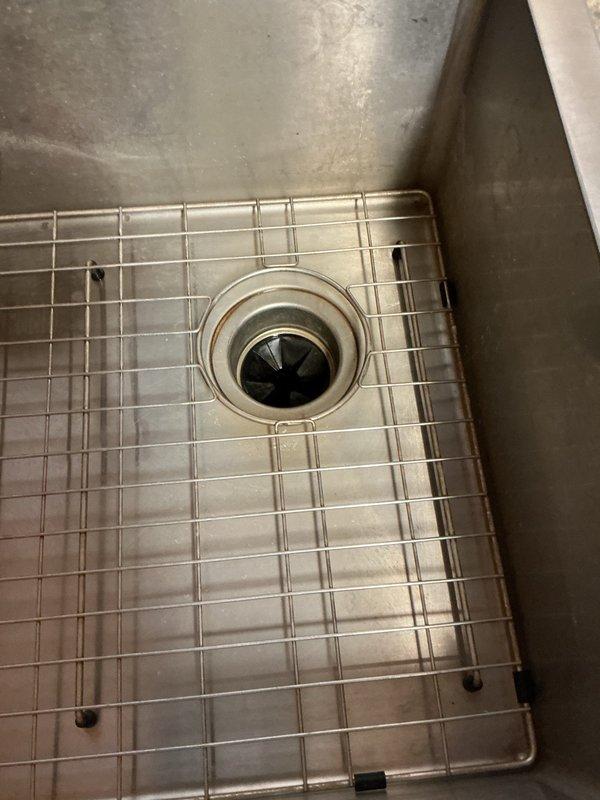 Responded to service call for seized and leaking garbage disposal. Removed and replaced failed unit with new garbage disposal, verified proper operation and checked all connections for leaks. Additionally installed customer-supplied bathroom sink faucet and tested for proper function and leaks. All plumbing fixtures operational upon completion with no active leaks detected.