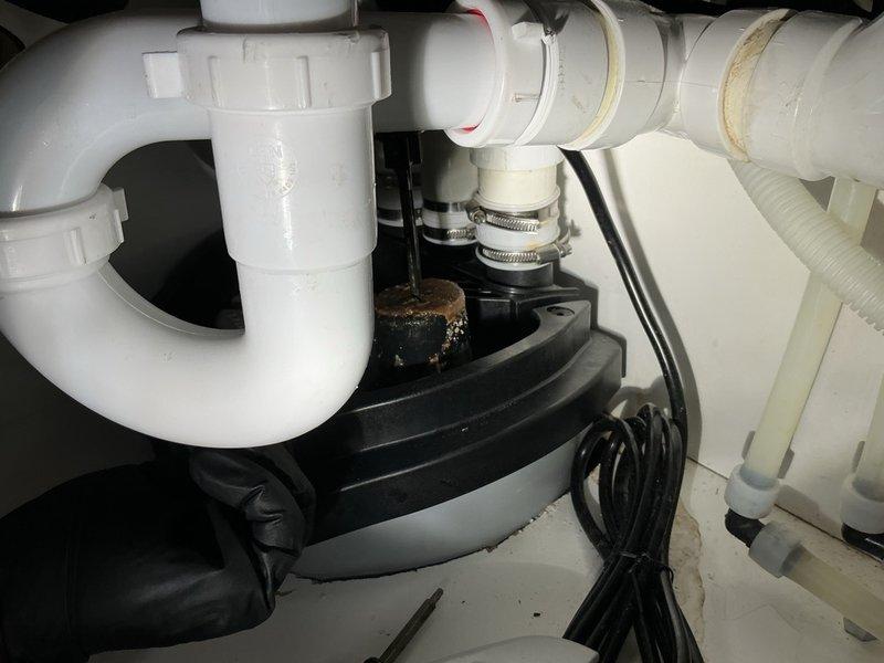 Responded to a recurring overflow issue with a Liberty pump system beneath a commercial sink. Upon inspection, discovered the float mechanism was heavily contaminated with grease buildup, preventing proper operation and causing the pump to malfunction. Disassembled the float assembly, thoroughly cleaned all grease and debris from the float and accessible pump components, and reassembled the unit. Tested the pump through ten complete cycles to verify proper operation and reliable activation. Additionally, installed a water alarm by drilling it into the standpipe to provide early warning monitoring for future water level concerns. System restored to full functionality with enhanced monitoring capability in place.