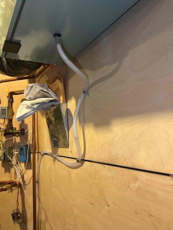 Responded to callback for water leaking from condensate drain line installed the previous week. Upon inspection, determined that the drain line was not installed with a proper trap loop, causing drainage issues and water leakage. Installed proper loop in the drain line per manufacturer specifications and tested system operation. Verified condensate now drains properly with no leaks present.