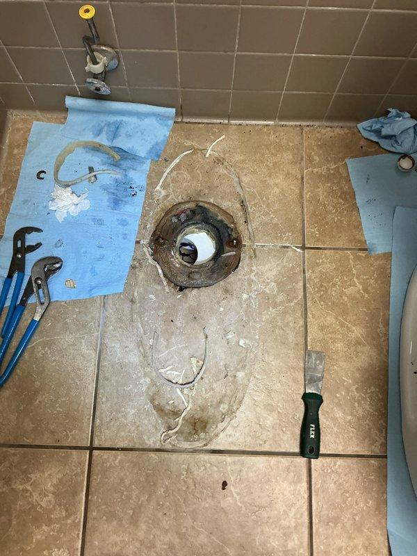 Responded to service call for toilet with rusting mounting hardware. Removed and reset toilet, replacing corroded closet bolts and wax ring seal. Upon inspection, found significant rust on toilet flange and deteriorated mounting screws that compromised the fixture's stability. Removed toilet from flange, cleaned work area, installed new wax ring, and properly secured toilet with new stainless steel closet bolts and hardware to ensure watertight seal and prevent future corrosion issues.