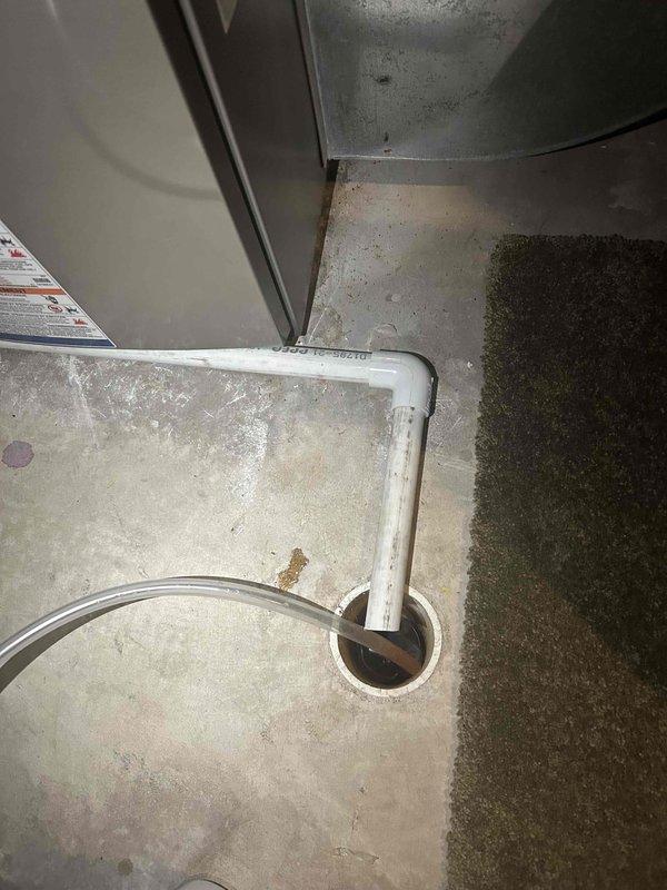 Responded to follow-up call on recently installed furnace where condensate drain pipe was improperly positioned, laying across the top of the floor drain rather than extending into it, causing water to drip onto the concrete floor and create moisture damage. Installed a 90-degree elbow fitting to the drain pipe to properly direct it down into the floor drain, eliminating the water spillage issue. No diagnostic charges applied as this was a new equipment installation follow-up to correct the drain configuration.