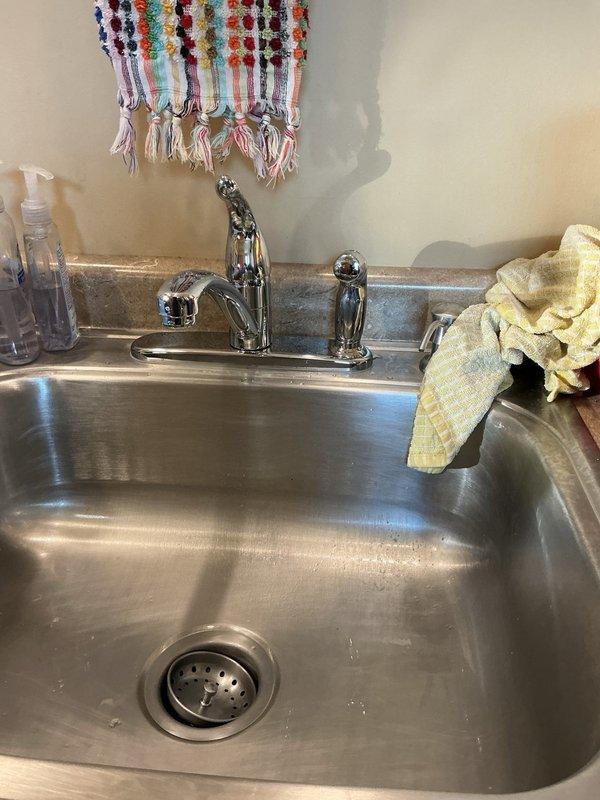 Completed comprehensive plumbing inspection of residential property with well water system. Replaced leaking kitchen faucet that was disassembled and non-functional. Replaced both corroded angle stop valves under kitchen sink that would not operate. Inspected blue pressure tank and associated plumbing connections in basement utility area. Noted water heater drain valve was plugged and unable to flush unit per original request; proceeded with other repairs as directed. Verified installation of new fixtures and completed system inspection.