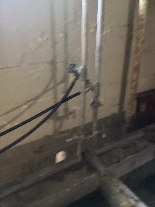 Completed routine plumbing inspection of basement utility area, examining vertical drainage lines, PVC piping system, and sump pump installation. All plumbing infrastructure, including brass valve connections and drainage components, were visually inspected and documented with photos for maintenance records.