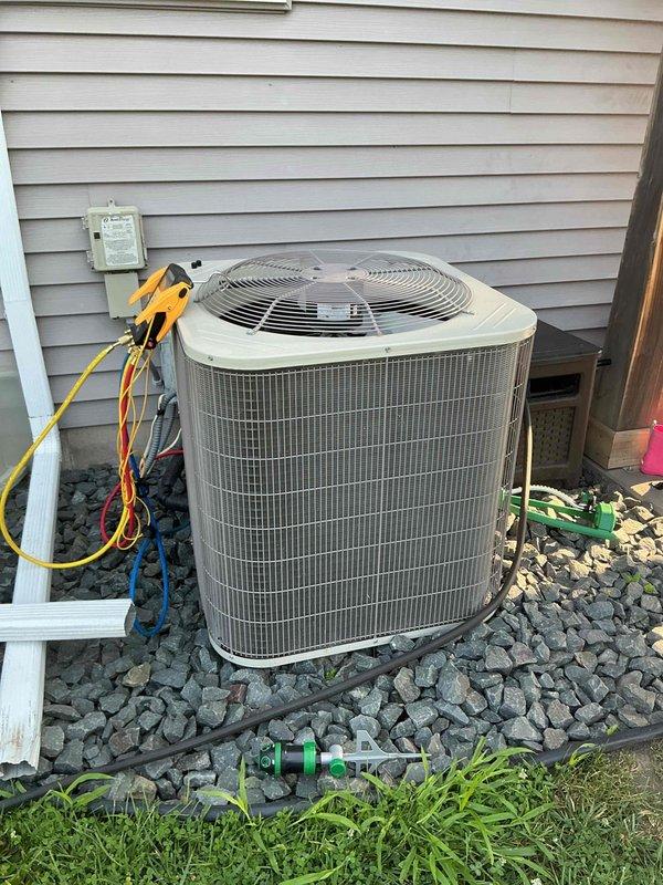 Responded to no cooling complaint on one-year-old air conditioning system experiencing intermittent condenser operation and warm air delivery. Diagnostic testing with manifold gauges revealed low refrigerant charge causing system to cycle off prematurely. Customer will contact original installer to address refrigerant leak and recharge system under warranty.