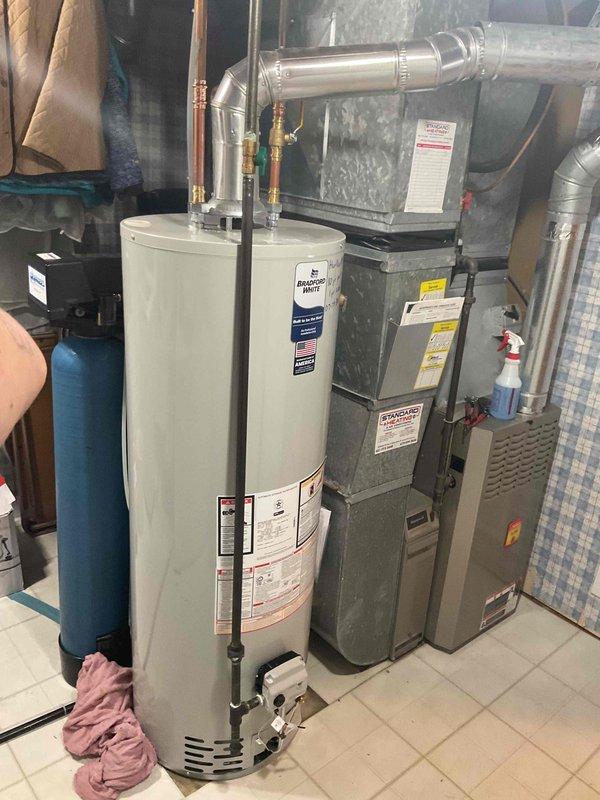 Responded to service call for leaking 40-gallon natural gas water heater. Upon inspection, identified active leak originating from bottom of tank on 2013 Rheem unit, indicating internal tank failure. Removed and properly disposed of failed water heater. Installed new Bradford White 40-gallon natural gas water heater with 10-year parts and 1-year labor warranty. Connected copper supply lines with brass fittings, installed proper venting system, and tested all connections for leaks. Verified proper gas combustion, temperature settings, and overall system operation before completing installation.