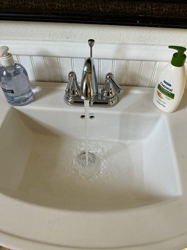 Responded to a clogged bathroom sink drain caused by excessive hair accumulation in the tailpiece and trap assembly. Disassembled the P-trap, removed all hair buildup from both the trap and tailpiece, and reassembled the drain system. Verified proper water flow and drainage upon completion, with sink now functioning normally.