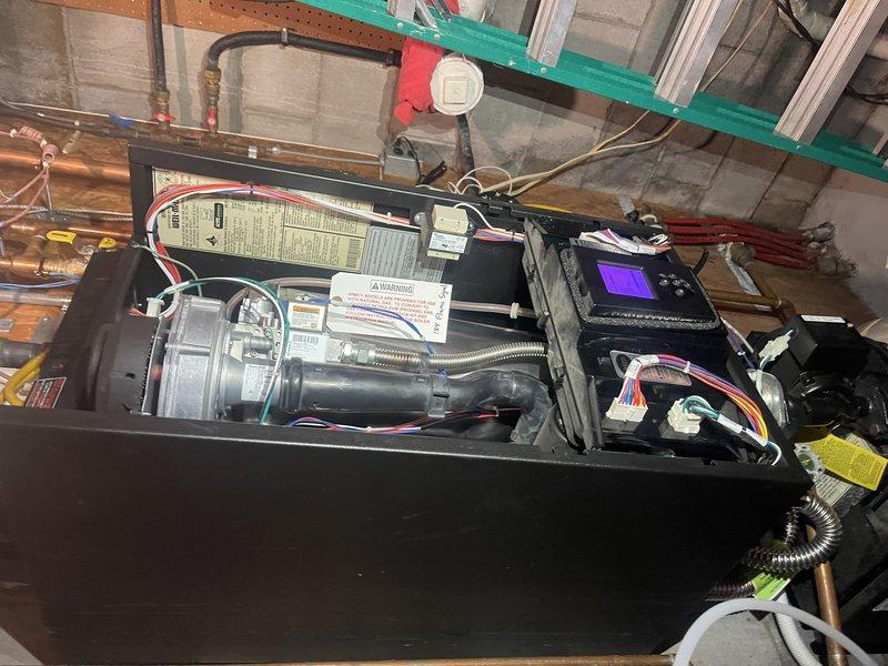 Responded to callback for boiler water leak on floor. Removed insulation to access heat exchanger and water tank, traced leak source to condensate line. Disassembled and thoroughly flushed condensate line, cleared blockage in drain pipe. Reassembled system and tested operation—unit ran properly with no visible leaking. However, suspect potential pinhole leak in heat exchanger that may be allowing boiler water to drain internally. Resolved immediate floor water issue through condensate system cleaning. Recommend monitoring hydronic side for low water conditions during fall maintenance visit, as homeowner shuts off water supply when away from property, making continuous observation difficult during summer months.