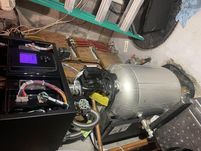 Responded to callback for boiler water leak on floor. Removed insulation to access heat exchanger and water tank, traced leak source to condensate line. Disassembled and thoroughly flushed condensate line, cleared blockage in drain pipe. Reassembled system and tested operation—unit ran properly with no visible leaking. However, suspect potential pinhole leak in heat exchanger that may be allowing boiler water to drain internally. Resolved immediate floor water issue through condensate system cleaning. Recommend monitoring hydronic side for low water conditions during fall maintenance visit, as homeowner shuts off water supply when away from property, making continuous observation difficult during summer months.