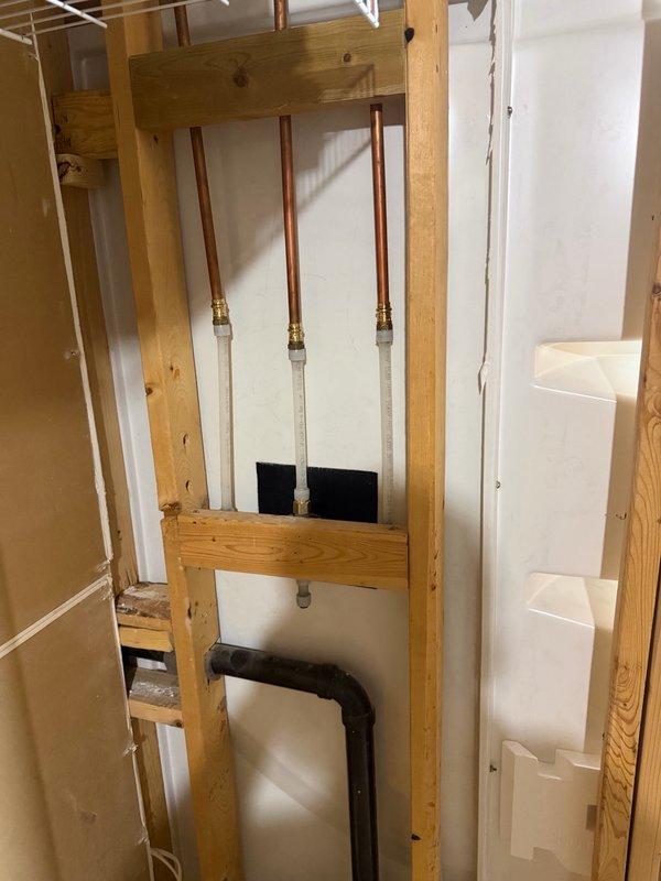 Replaced and installed Kohler shower valve in basement utility area. Completed rough-in plumbing installation with copper pipe connections and PEX transitions, ensuring proper valve operation and secure mounting within exposed wall framing.