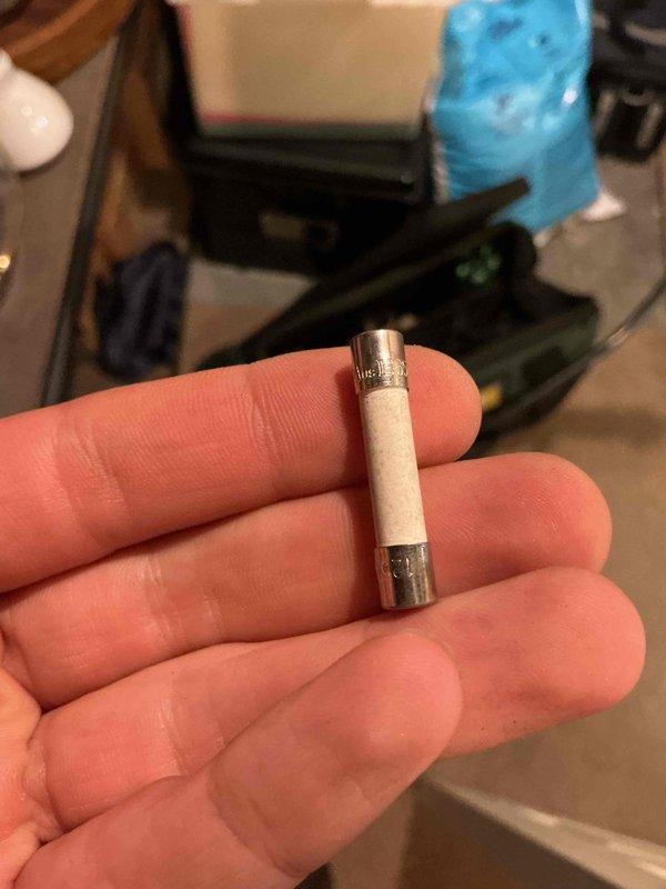 Responded to install callback for newly installed boiler that would not power on and was repeatedly blowing 5 amp fuses, leaving property without hot water. Performed diagnostic troubleshooting and isolated issue to failed transformer inside boiler unit. Verified transformer had continuity but failed to operate properly under load. Confirmed fuse operated correctly when transformer was disconnected from circuit. Documented findings with photos of blown fuse and internal wiring configuration. Unit requires transformer replacement to restore operation.