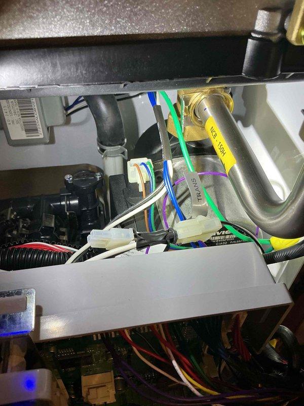 Responded to install callback for newly installed boiler that would not power on and was repeatedly blowing 5 amp fuses, leaving property without hot water. Performed diagnostic troubleshooting and isolated issue to failed transformer inside boiler unit. Verified transformer had continuity but failed to operate properly under load. Confirmed fuse operated correctly when transformer was disconnected from circuit. Documented findings with photos of blown fuse and internal wiring configuration. Unit requires transformer replacement to restore operation.