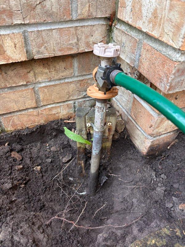 Responded to service call for non-functioning outdoor spigot with water bubbling up through ground instead of flowing from fixture. Upon inspection, determined issue was related to underground irrigation system rather than the hose bib or interior plumbing supply lines. Advised customer to contact irrigation company for repair of subsurface leak in irrigation piping causing water to surface around spigot base.