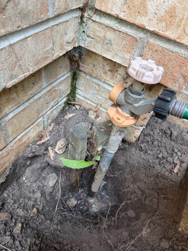 Responded to service call for non-functioning outdoor spigot with water bubbling up through ground instead of flowing from fixture. Upon inspection, determined issue was related to underground irrigation system rather than the hose bib or interior plumbing supply lines. Advised customer to contact irrigation company for repair of subsurface leak in irrigation piping causing water to surface around spigot base.