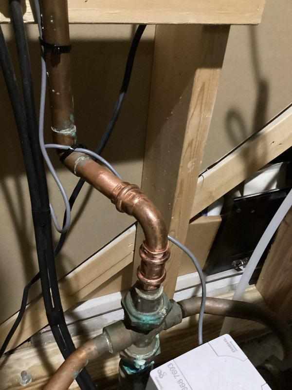 Responded to water leak at main supply line where elbow fitting above the water meter showed active leaking. Removed and replaced the defective elbow section and associated pipe segment with new copper components. Verified all connections were secure and tested system under full pressure to confirm leak was eliminated and proper water flow was restored.