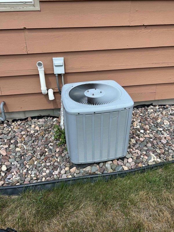 Responded to no cooling concern on 9-year-old Daikin system. Upon arrival, thermostat was set to 73°F and maintaining setpoint. Performed comprehensive system evaluation and maintenance tune-up. Cleaned outdoor condenser coil with water to remove debris and restore airflow. Inspected all electrical connections and components at condensing unit – found secure and within specifications. Evaluated indoor evaporator coil operation – confirmed proper refrigerant flow with full coil sweating pattern. Measured temperature split across evaporator at 18°F, indicating correct system performance. Verified all indoor components functioning properly. Explained to homeowner that recent perceived cooling inadequacy was due to extreme weather conditions with mid-90s temperatures and high humidity levels, which exceed normal design parameters for residential equipment. System operating as designed with no deficiencies found.