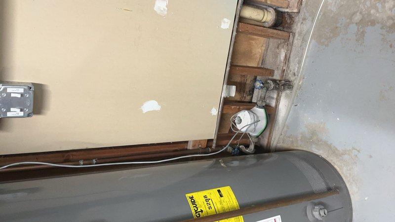 Coordinated with municipal water department to schedule water shutoff between 8am-9am to facilitate replacement of main water line valve and adjacent valve located near the water meter. Provided estimate for main valve replacement and documented existing plumbing configuration with photos showing exterior utility connections and interior water heater installation with associated copper piping.