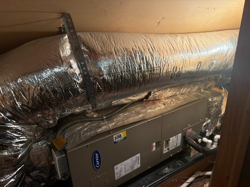 Responded to no cool complaint on residential property with two 16+ year old Carrier AC systems struggling to maintain temperature during hot weather. Performed diagnostic evaluation on both attic and basement units.

**Attic Unit Findings:**
Identified low refrigerant charge causing reduced cooling capacity. Observed partial evaporator coil freeze-up due to insufficient refrigerant levels. System operating outside normal parameters. Discussed repair options with homeowner and scheduled service advisor visit for comprehensive evaluation and refrigerant leak detection/repair recommendations.

**Basement Unit Findings:**
Tested capacitor and found weakened performance approaching failure threshold. All other components including compressor, blower motor, and controls operating within specifications. Verified refrigerant charge at proper levels. Measured supply and return air temperatures confirming 20-degree temperature split, within acceptable range for proper system operation.

**Servi