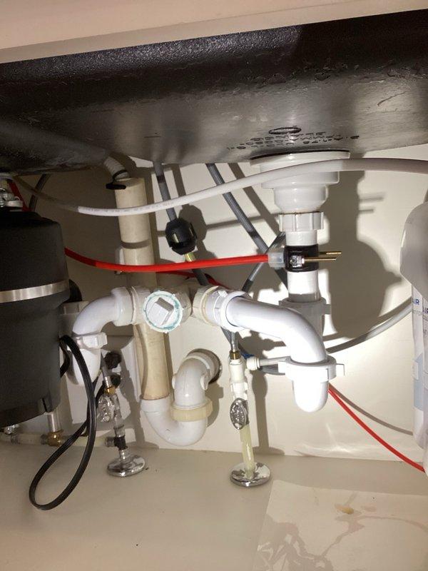 Responded to service call for reverse osmosis system producing excessive gurgling noise during water production cycle. Upon arrival, observed unit gurgling loudly while filling storage tank and discharging to drain. Monitored system for approximately 10 minutes to verify automatic shut-off functionality, which operated correctly once tank reached capacity. Isolated the RO system from water supply and depressurized the unit. Disconnected drain line from saddle valve connection and removed accumulated debris causing flow restriction. Thoroughly cleaned saddle drain port to restore proper drainage. Reconnected drain hose and cycled system through production mode to verify repair. Gurgling noise reduced significantly to minimal operational sound levels. System functioning as designed with proper shut-off cycle and quieter operation. Advised that debris accumulation may recur over time due to drain line configuration and water conditions, potentially requiring periodic maintenance.