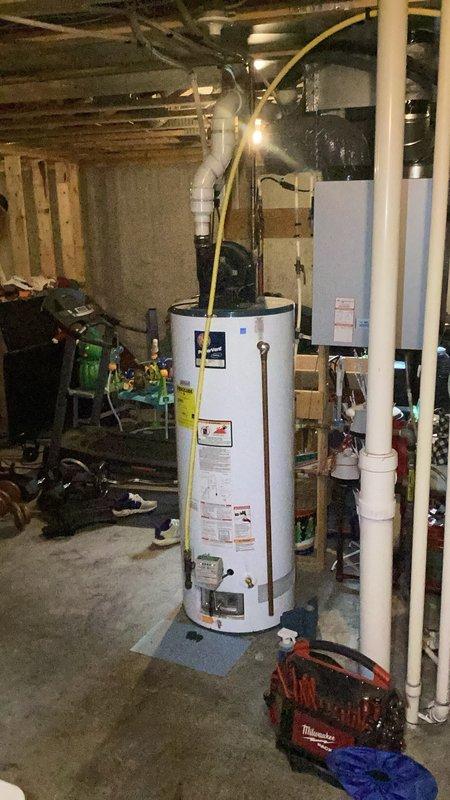 Responded to no hot water condition on 17-year-old tanked water heater equipped with flammable vapor sensor. Upon arrival, diagnosed repeated vapor sensor failure preventing unit reset despite homeowner's previous sensor replacement and troubleshooting attempts. Determined water heater control system would not clear fault codes and unit could not be restored to operation. Documented existing installation with yellow flexible gas lines, PVC venting, and copper water connections in unfinished basement mechanical room. Recommended and sold replacement water heater installation scheduled for following morning due to age of existing unit and recurring sensor failures making further repairs uneconomical.