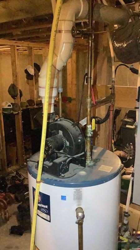 Responded to no hot water condition on 17-year-old tanked water heater equipped with flammable vapor sensor. Upon arrival, diagnosed repeated vapor sensor failure preventing unit reset despite homeowner's previous sensor replacement and troubleshooting attempts. Determined water heater control system would not clear fault codes and unit could not be restored to operation. Documented existing installation with yellow flexible gas lines, PVC venting, and copper water connections in unfinished basement mechanical room. Recommended and sold replacement water heater installation scheduled for following morning due to age of existing unit and recurring sensor failures making further repairs uneconomical.