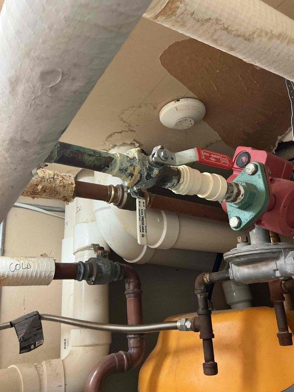 Responded to no cooling complaint on PTAC unit. Upon arrival, activated unit and observed blower motor operating normally, but compressor exhibited bucking behavior and failed to start. Deactivated system and performed diagnostic testing on electrical components. Testing indicated compressor was grounded out, rendering it inoperable. Advised property owner that due to age and condition of unit, full PTAC replacement would be most cost-effective solution rather than compressor replacement. Owner declined replacement service and indicated intent to source and install unit independently. During visit, owner mentioned additional plumbing concerns in mechanical room area, including issues with water heating equipment and overhead piping. Documented plumbing needs and submitted follow-up request for coordinated service visit with plumbing technician to address water system concerns. Photographed mechanical room showing water heater with visible labeling, hot and cold water distribution lines