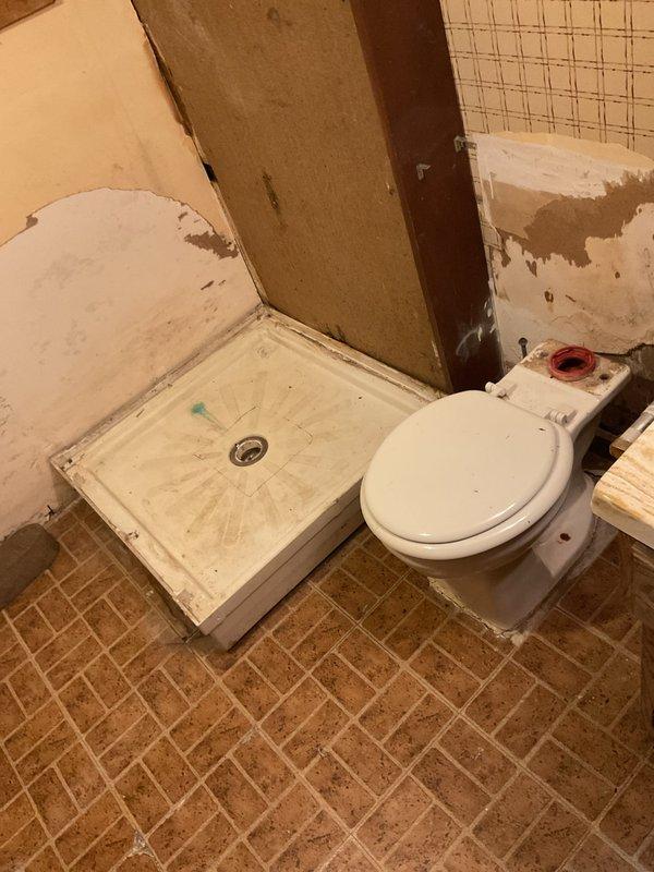 Responded to service call for bathroom fixture removal. Assessed existing conditions including deteriorated shower base and toilet requiring removal. Documented current state of bathroom showing worn fiberglass shower pan with staining and toilet in place. Walls displayed significant deterioration requiring attention during removal process. Provided detailed pricing options and discussed project scope with customer for complete removal of both fixtures.