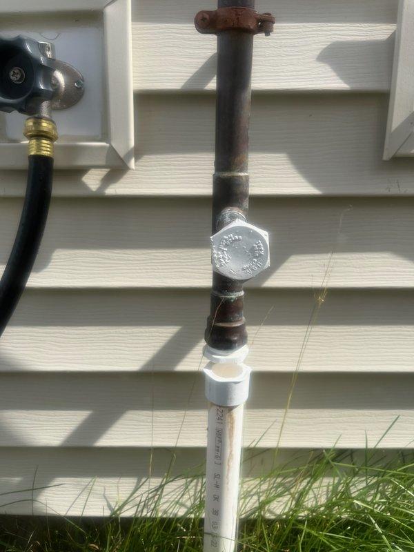 Responded to main water line leak located after the meter and outdoor irrigation system failure. Investigation revealed the irrigation system had not been properly winterized, resulting in freeze damage that caused a burst pressure vacuum breaker (PVB) and associated copper piping. Removed damaged copper supply lines and failed PVB assembly from exterior wall mounting location. Installed new pressure vacuum breaker with proper brass fittings and replaced deteriorated copper sections with new PVC piping and appropriate transition adapters. Secured all components to building exterior using proper mounting hardware. Tested system for proper operation and verified no additional leaks present. All repairs completed to code specifications.
