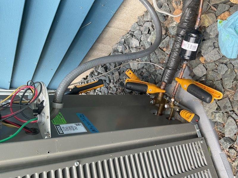 Responded to no-cool complaint on Lennox air conditioning system. Upon arrival with 85°F outdoor ambient, found unit was cooling but unable to maintain 74°F setpoint due to multiple contributing factors. Measured subcooling at 11° versus manufacturer target of 5°, indicating overcharged refrigerant circuit. Recovered 8 oz of refrigerant to bring charge to proper specification. Verified airside performance with return air temperature at 70.5°F and supply air at 53°F, yielding acceptable 17.5°F temperature split.

Identified restricted airflow caused by decorative wood supply register covers significantly limiting air delivery throughout home. Removed restrictive covers to improve supply air velocity and system performance. Conducted thermal inspection revealing major heat gain issue at hallway attic fan located above thermostat, with surface temperatures measuring 108°F at louvers due to missing insulation and inadequate sealing. This radiant heat was influencing thermostat sensing and 
