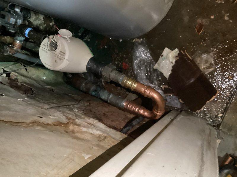 Responded to emergency water leak in building's main water line. Upon arrival, identified pinhole leak in corroded copper pipe adjacent to the main water supply line near the meter. The shutoff valve and surrounding pipe showed significant corrosion from age and moisture exposure. Isolated the affected section by shutting off water supply to the entire building from the street-level main valve to prevent further water damage and allow safe repairs.

Cut out the compromised section of copper pipe containing the pinhole leak and replaced with new piping and fittings. Completed proper soldering and connections to restore water main integrity. Tested all connections for leaks and verified proper water pressure throughout the system. Restored water service to the building and confirmed shutoff valve operation. Documented existing conditions including water pooling on concrete floor and moisture damage in the utility area, along with corroded plumbing components requiring monitoring for futu