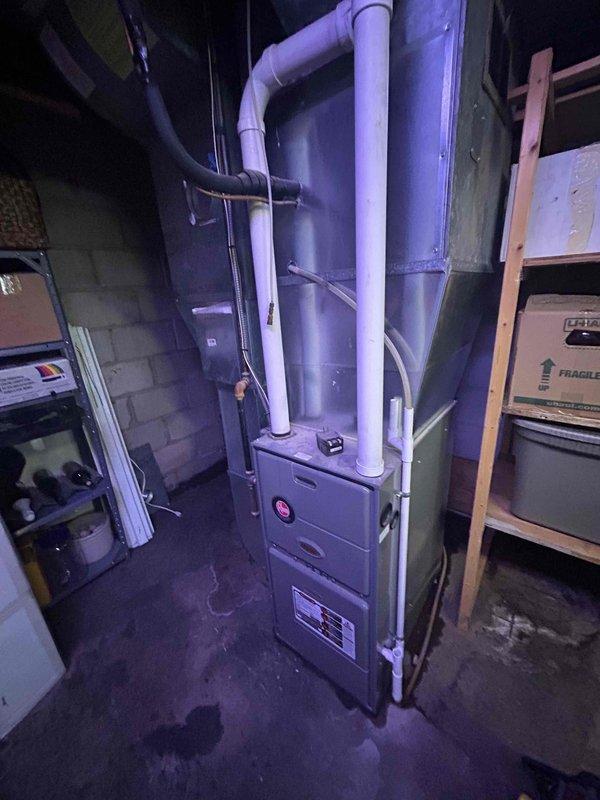 Responded to water leakage complaint around furnace area. Found condensate drain line completely plugged, causing water to overflow and pool on floor. Cleared blockage by blowing out drain line, releasing significant volume of trapped water. Flushed condensate pan thoroughly with water to ensure proper drainage. Performed complete furnace tuneup at homeowner's request with no additional issues found. System operating normally upon departure.