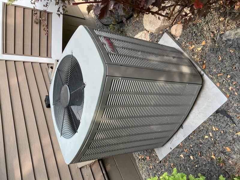 Responded to no cooling complaint on residential split system air conditioning unit. Upon arrival, verified thermostat was calling for cooling at 75 degrees setpoint. Inspected air filter and blower speeds, both found satisfactory. Observed outdoor unit contactor not receiving 24V control voltage from thermostat, though 240V line voltage was present. Tested capacitor, found within specifications. Discovered outdoor coil heavily blocked with cottonwood debris, restricting airflow. Cleaned condenser coil thoroughly, restoring proper airflow. Replaced thermostat batteries and verified wire connections secure.

During further inspection, found blower operating at lowest speed setting and reset button on furnace door switch tripped. Reset safety switch, restoring unit operation. Cycled power to system by disconnecting and reconnecting wiring to confirm proper startup. Checked refrigerant charge and found system operating below optimal levels. Measured supply and return air temperature diffe