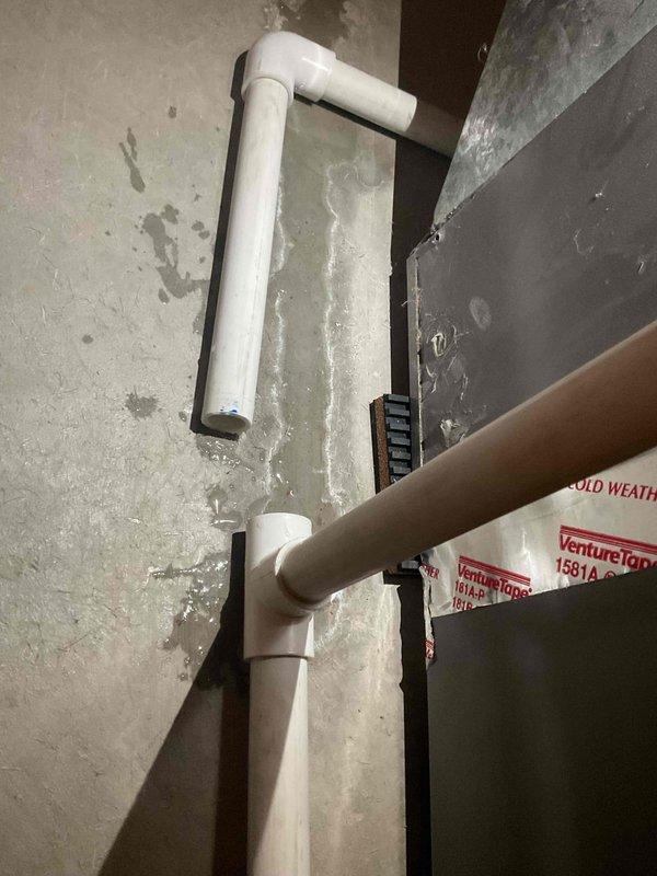 Responded to water leak at Lennox furnace caused by improperly installed condensate drainage system. Found PVC tee fitting at rear of furnace was not glued during original installation, resulting in active water leakage. Properly cleaned and glued PVC connection at tee fitting, reconnected high voltage power to furnace and air conditioning system, and verified system operation with no further leaks detected.