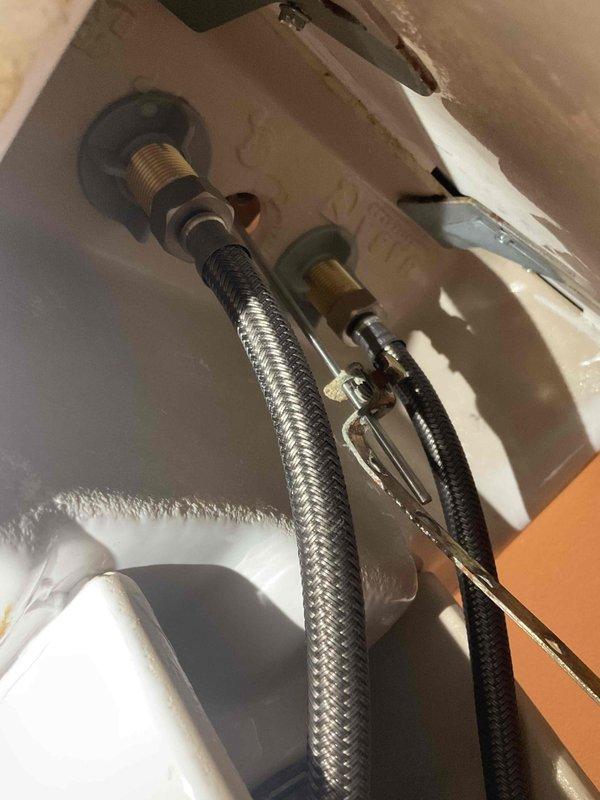 Responded to callback for leak at bathroom faucet following recent water supply line replacement. Upon inspection, identified internal leak at cold water stem within faucet body. Verified flexible supply line connections at wall-mounted shutoff valves and fixture tailpieces were properly installed and secure with no external leakage. Diagnosed failure of internal faucet cartridge/stem assembly causing water seepage. Documented existing plumbing configuration including braided stainless steel and black braided supply lines with brass compression fittings. Provided quote for complete faucet replacement as internal component repair not viable option for this unit.