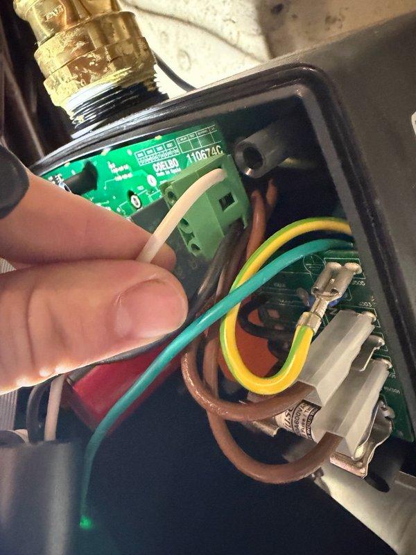 Responded to low water pressure complaint and diagnosed residential water pressure boosting system with ResiBoost variable frequency drive controller. Upon inspection, found controller had short circuited and displayed persistent error code A7 even after disconnecting pump and resetting unit. Tested system components and confirmed controller failure requiring replacement. Documented existing installation showing blue electric pump motor with metallic housing, copper piping connections, and failed ResiBoost control unit mounted on pump assembly. Photographed internal circuit board damage and wiring configuration for reference. Due to specialized nature of ResiBoost VFD programming and limited technician availability in the area for this equipment, provided estimate for new controller installation to restore proper water pressure boost functionality to the residential water system.