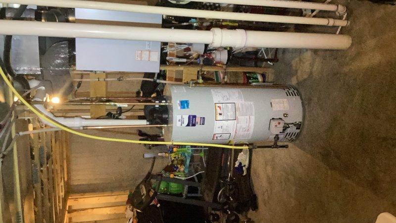 Completed installation of 50-gallon natural gas power vent water heater in basement utility area, replacing existing unit of similar specifications. Connected all supply and discharge lines, installed white PVC venting system extending to proper termination point, and ensured all gas connections met code requirements. Verified proper operation of power vent motor, tested all safety controls, and confirmed adequate combustion air supply. Installation included obtaining applicable permit and final inspection approval. Unit positioned on concrete floor with appropriate clearances maintained for service access and safe operation per manufacturer specifications and local plumbing codes.