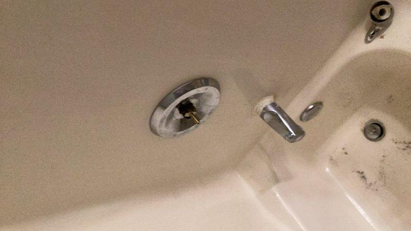 Responded to service call for leaking shower handle on extremely aged Moen shower valve with no visible manufacturer markings. Upon inspection, identified severe hard water buildup affecting cartridge operation. Successfully replaced worn shower cartridge, but handle mount broke during removal due to age and mineral deposits. Installed new mounting hardware to complete repair and restore full functionality to shower valve assembly.