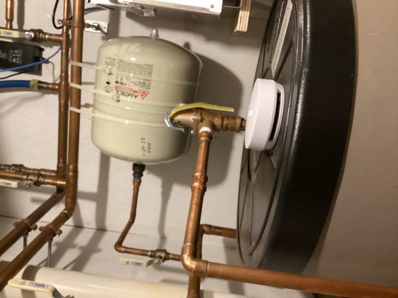 Responded to water leak concern in utility area following initial tune-up visit. Upon inspection, identified failed expansion tank on indirect domestic water heater as source of water accumulation on floor, evidenced by wall staining and moisture damage visible in mechanical room. Contacted homeowners with findings and diagnosis; customer approved deferring expansion tank replacement until the following Monday.